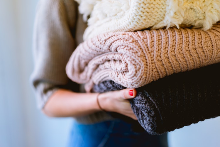 instagram için sonbahar fotoğraf fikirleri - onun elinde katlanmış kazak olan bir kız